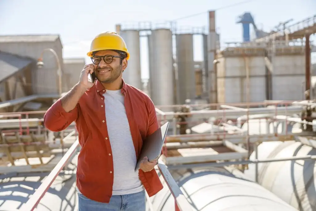 Hombre en planta industrial con laptop.